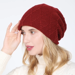 Close-up of wine red knitted beanie with diamond pattern and warm fleece lining texture