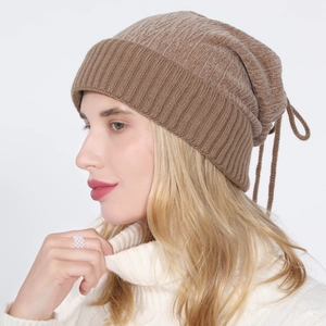 Detail of warm brown ribbed knit beanie with stylish drawstring and thick texture