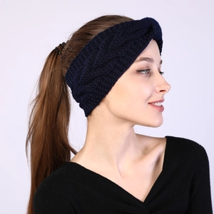 Detail of navy blue cable knit twist headband showing warm winter texture on model