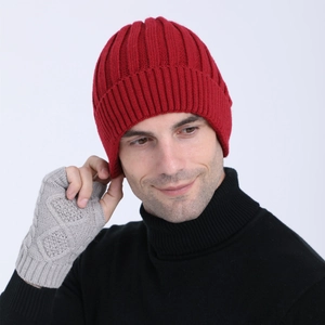 Detail view of red ribbed knit beanie and grey pattern gloves on a model