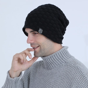Detail of black knit beanie featuring a checkered texture and white bear logo patch