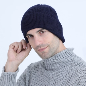 Detailed view of dark blue cable knit beanie with thick texture and ribbed design
