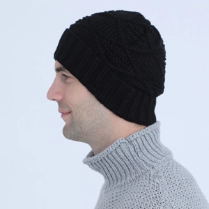 Detail of black knit beanie featuring textured diamond pattern and wide folded brim