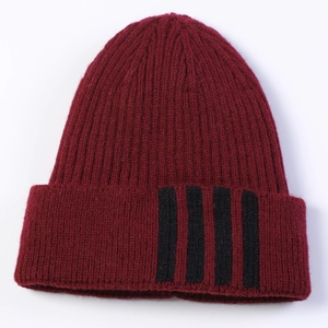 Detail of burgundy ribbed knit beanie with four black stripes on the folded cuff