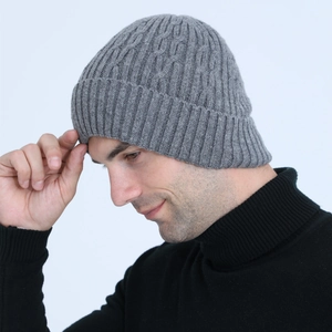 Detailed close-up of grey cable knit beanie showing thick wool texture and ribbing