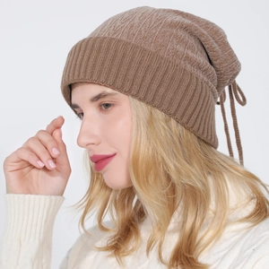 Close-up of brown ribbed knit beanie with foldable earflaps and adjustable tie strings