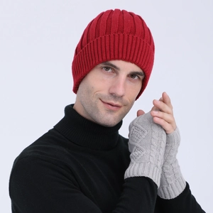 Detail of red ribbed knit beanie and grey cable knit fingerless gloves set for winter