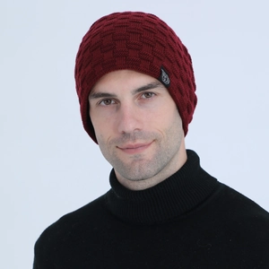 Detail of dark red knit beanie showing checkered texture and logo patch on the side
