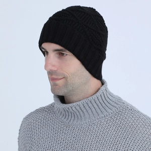 Close-up of black knit beanie featuring thick cable patterns and a wide ribbed edge