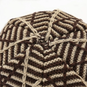 Macro shot of knitted beanie top with geometric diamond pattern in brown and beige mix