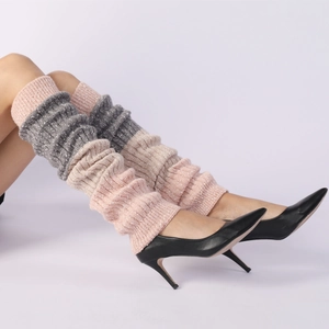 Close-up of color-block knit leg warmers in pink, grey, and beige with high heels