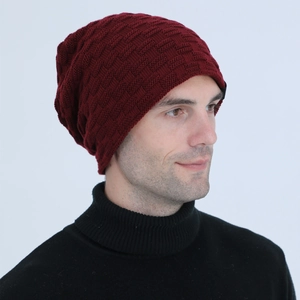Close-up of wine red knitted beanie featuring a textured square pattern and warm fabric