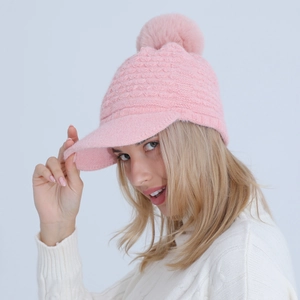Detail of pink knitted beanie with soft brim, faux fur pompom and diamond weave texture
