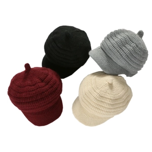 Detail of ribbed knit winter hats in burgundy, black, gray, and beige colors