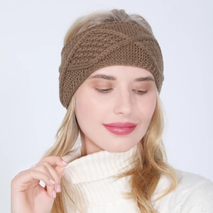 Detailed close-up of a dark brown knit headband showing intricate cable patterns and texture