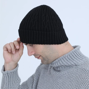 Close-up of black cable knit beanie with fleece lining and ribbed detail for men