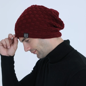 Detail of burgundy ribbed knit beanie showing textured checkerboard pattern and logo patch