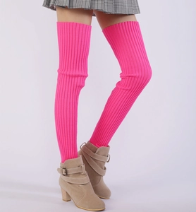 Macro detail of vibrant pink ribbed knit leg warmers showing texture and fit over boots