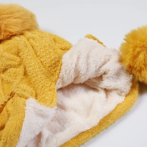 Dettaglio della morbida fodera in pile bianco in un cappello invernale giallo a maglia