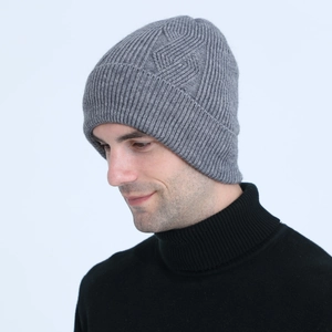 Detail view of dark grey knitted beanie with textured cable patterns and thick winter material