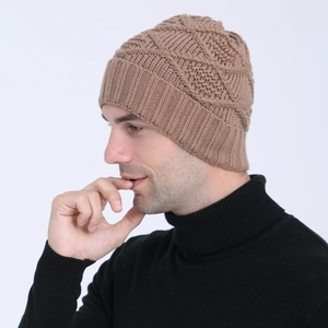 Close-up of brown knitted beanie with diamond pattern and ribbed hem on male model