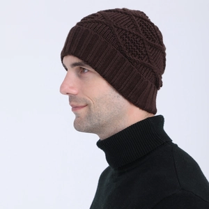Detail of dark brown knit beanie showing diamond pattern and ribbed cuff on model