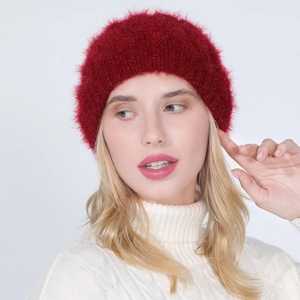 Close-up of deep red knit beanie with soft plush texture worn by a model