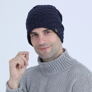 Close-up of men's navy blue knit beanie featuring textured square patterns and side patch