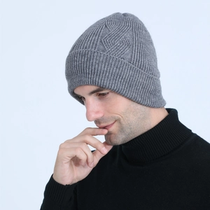 Detail view of men's grey cable knit beanie with ribbed texture and warm folded cuff