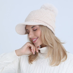Detailed close-up of a warm cable knit visor beanie with a fluffy faux fur pom-pom