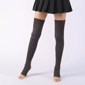 Detail of dark brown knit stirrup leg warmers showing ribbed texture and over-knee length