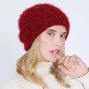 Detail of burgundy knit beanie featuring subtle metallic shimmer and soft faux fur texture