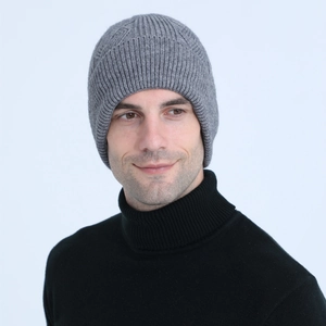 Detail of grey cable knit beanie showing thick vertical ribbed texture and warm ear protection