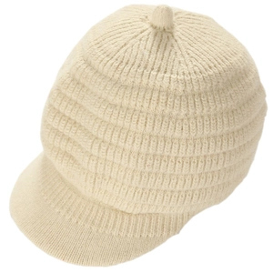 Close-up of oatmeal knit newsboy cap showing vertical striped texture and pom-pom detail