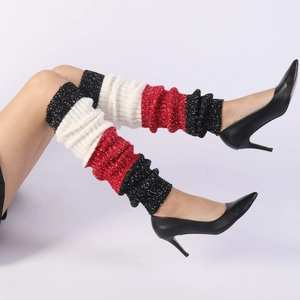 Detail of color-block knit leg warmers showing thick red white black textured fabric