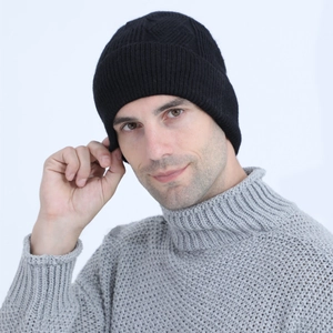 Close-up of black cable knit beanie with diamond pattern and warm ribbed ear protection