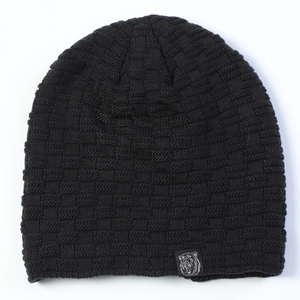 Close-up of black beanie showing checkerboard knit texture and animal head logo patch