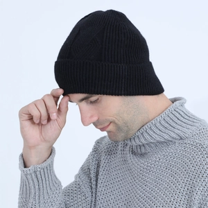 Close-up of black cable knit beanie with ribbed cuffs and warm textured fabric for winter
