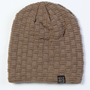 Macro detail of brown knitted beanie showing basket weave texture and bear patch