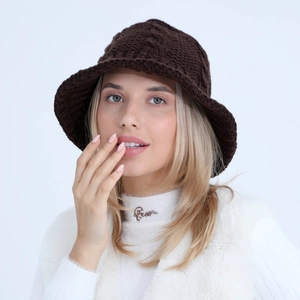 Close-up of deep brown chunky knit bucket hat featuring intricate cable knit textures