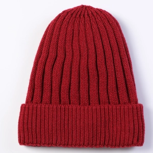 Close-up of the thick rib-knit texture and deep red wool blend fabric of the beanie
