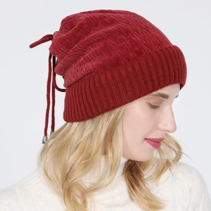 Detail of dark red knit beanie featuring vertical texture and adjustable drawstring