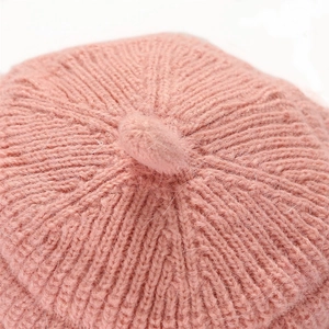 Close-up of pink knit beret featuring warm fuzzy texture and radial weave pattern