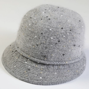 Gros plan sur un chapeau cloche gris en maille épaisse avec détails dorés brillants