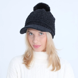 Close-up of black winter knitted visor hat for women with soft faux fur pompom detail
