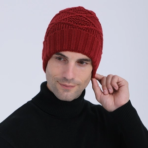 Close-up of deep red knitted beanie with diamond jacquard texture worn by male model