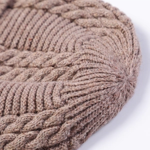 Detailopname van gebreide muts met kabelpatroon en warme wollen stof voor de winter