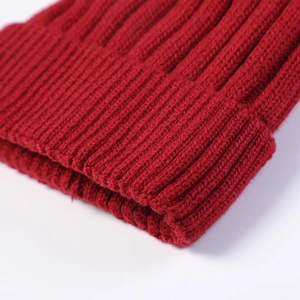 Close-up of deep red ribbed knit beanie showing thick texture and wool fibers