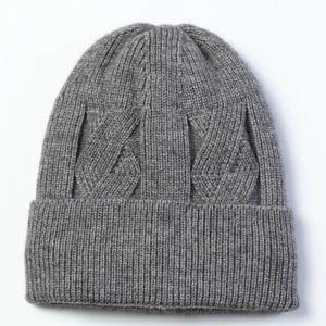 Close-up of thick cable knit pattern and warm grey wool texture on winter beanie hat