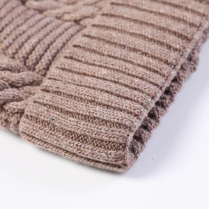 Detail van taupe kabelgebreide textuur en geribbelde manchet van de warme wintermuts